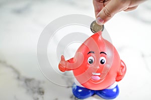 Man hand putting money coin into piggy bank for saving money weal photo