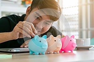 A Man hand putting money coin into piggy for saving money wealth and financial concept