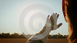 Man Hand Reaching Out To The Sun, Trying To Touch Sunrays