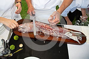 Man hand in restaurant outdoors party preparing fish fillets salmon meat