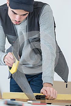 Man hand sawing piece wood