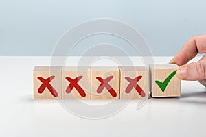 Man Hand selects checkbox with green checkmark from row of multiple boxes with red crosses. Right or Wrong. Concept of positive or