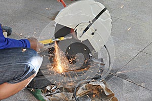 Man hand sharpen concrete drill bits by grinding machine