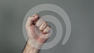 Man hand show fist on a grey background