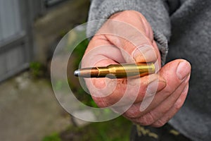 Man hand showing 7.62 caliber ammunition bullet