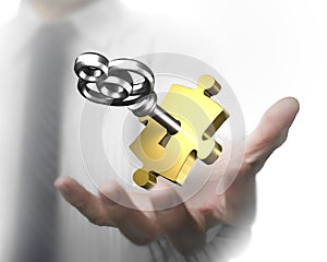 Man hand showing golden puzzle piece with silver key