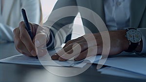 Man hand signing papers in office closeup. Insurance client checking agreement