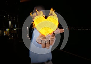 Man with hand spread of with heart fire icon over. City at night