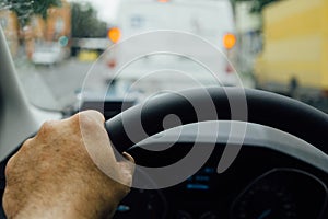 Man hand on steering wheel of a car