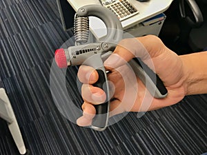 Close up man hand with strength handgrip to prevent office syndrome photo