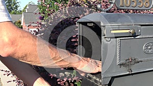 Man hand taking letter from mailbox