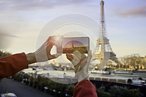 Man hand taking a photo of the sunset in Eiffel tower, Paris. France
