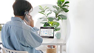 Man hand talking phone while working with digital tablet for mobile app development prototype at home office