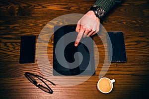 Man hand touch on a screen of mobile phone on a wooden table. Business situation.