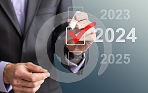 man hand touching on 2024 calender year button on digital virtual screen blur background