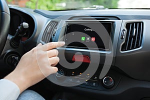 Man hand touching multimedia system with phone calling on screen