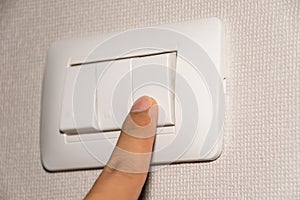 Man hand is turning on or off electrical light switch
