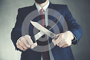 Man hand two knife on dark backgroun