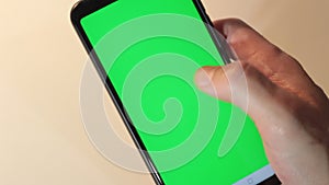 Man hand typing on green smartphone screen