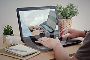 Man hand typing laptop with online learning on screen