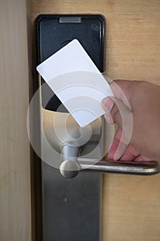 Man hand use key card switch in to open hotel room door