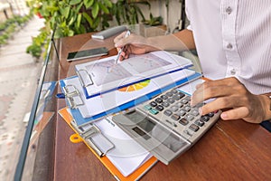 Man hand using calculator to check financial report