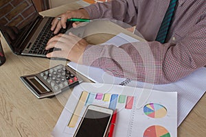Man hand using calculator and writing make note with calculate about cost at home office. The Man and computer are using a calcula