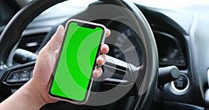 Man hand using green screen smart phone in the car