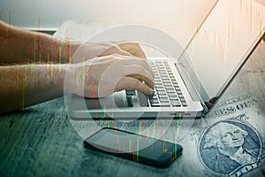 Man hand using laptop trading currencies and stocks on forex exchange. Candle stick graph and bar chart of stock market