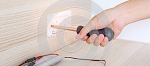 Man hand using screwdriver installing Wire cables for socket plug. Renovation, Repair, fixing and development of home and