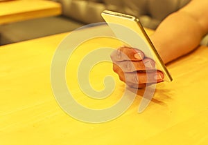 Man Hand, using smart mobile phone on the table indoor. Technology, communication concept