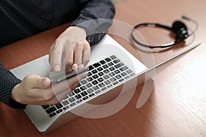 Man hand using VOIP headset with digital tablet computer docking