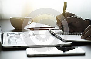 Man hand using writing pen memo on notebook paper or letter, diary on table desk office.