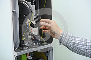 Man hand working with a gas condensing boiler disassembled, parts of section gas condenser
