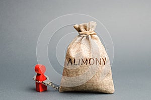 The man is handcuffed to a money bag with the word alimony. The concept of child support. Payments after a divorce. Financial photo