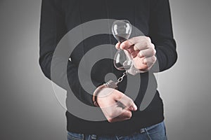 Man with handcuffs holding hourglass