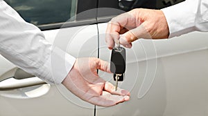 Man handing another person automobile keys new