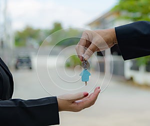 Man handing a house key to a woman
