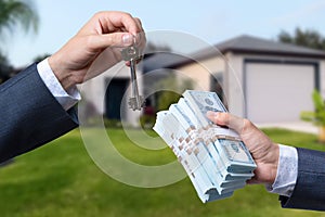 Man Handing a man Thousands of Dollars For Keys in Front of House.