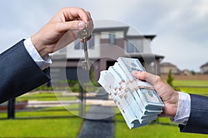 Man Handing a man Thousands of Dollars For Keys in Front of House.