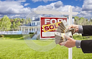Man Handing Over Money in Front Sold House and Sign