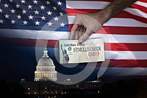 Man handing Stimulus check to people with the US Capitol and flag on the Background.