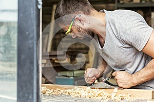 Man handles a wooden with a black jack plane