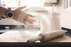 Man hands clapping with flour on the kitchen table