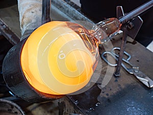 Man Hands Closeup Shaping Blown Glass Piece with a Wet mold