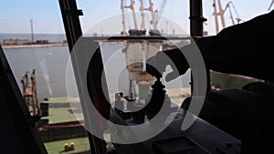 Man hands control joysticks at grain terminal operator cabin workplace. Worker controlling loading grain with arm lever