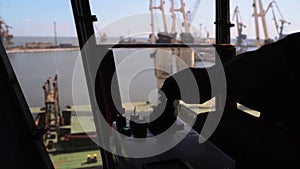 Man hands control joysticks at grain terminal operator cabin workplace. Worker controlling loading grain with arm lever