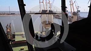 Man hands control joysticks at grain terminal operator cabin workplace. Worker controlling loading grain with arm lever