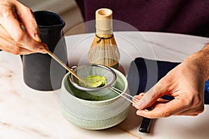 Man hands, Cooking green matcha tea during the Japanese ceremony. Traditional kit, Bamboo whisk and beverage, spoon shashaku,