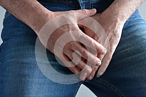 Man hands covering his painful crotch